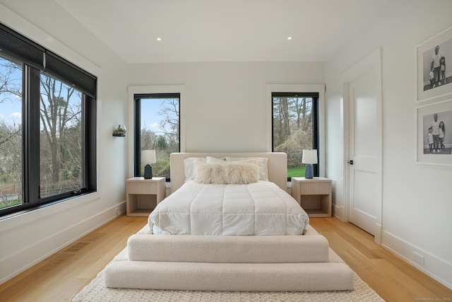 bedroom with light wood-style floors, baseboards, and recessed lighting