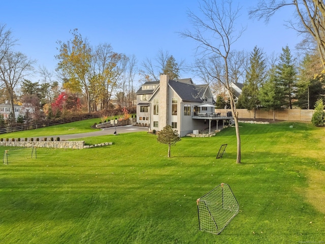 view of yard with fence, a wooden deck, and a patio area