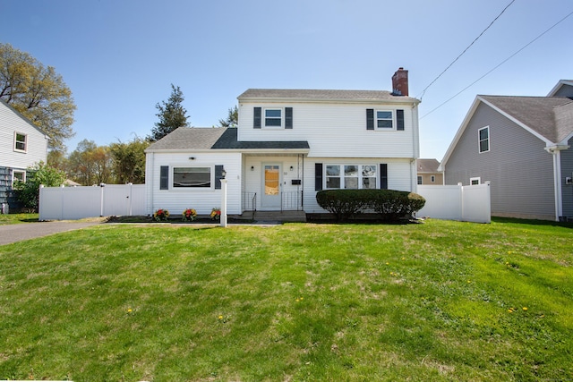 view of front of home featuring fence, a front yard, and a chimney