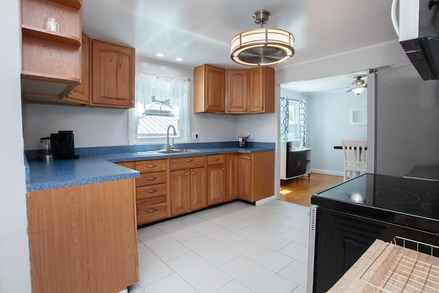 kitchen with a ceiling fan, freestanding refrigerator, dark countertops, electric range oven, and a sink