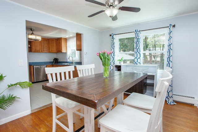 dining area featuring light wood-style floors, a baseboard radiator, and ceiling fan