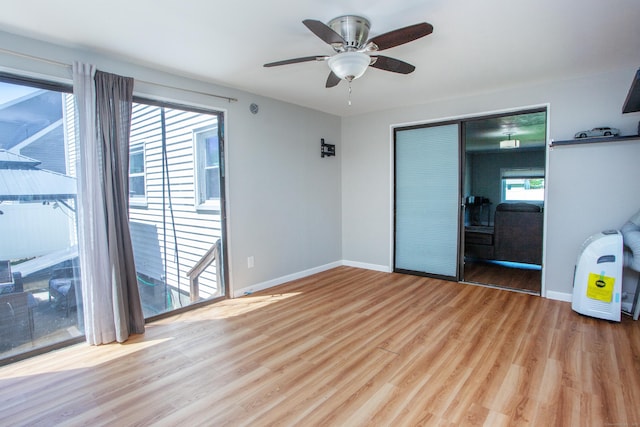 spare room with baseboards, a ceiling fan, and wood finished floors