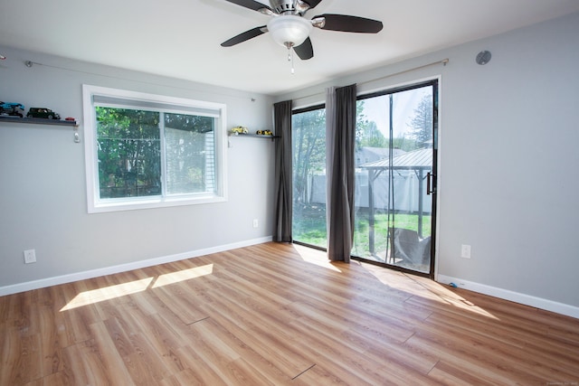 empty room featuring baseboards, ceiling fan, and light wood-style flooring