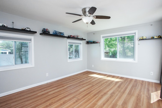 spare room with baseboards, ceiling fan, and wood finished floors