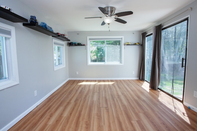 spare room with light wood-type flooring, baseboards, and ceiling fan