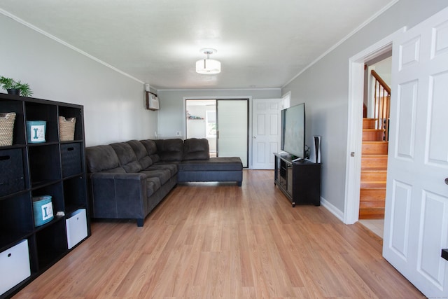 living area featuring crown molding, baseboards, light wood finished floors, and stairs