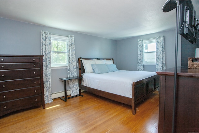 bedroom featuring light wood-style flooring and a baseboard radiator