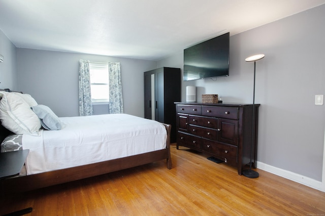bedroom featuring light wood-type flooring and baseboards