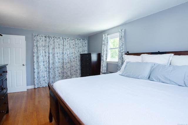 bedroom with baseboards and wood finished floors