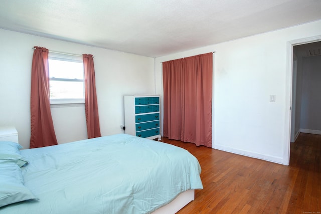 bedroom with baseboards and wood finished floors