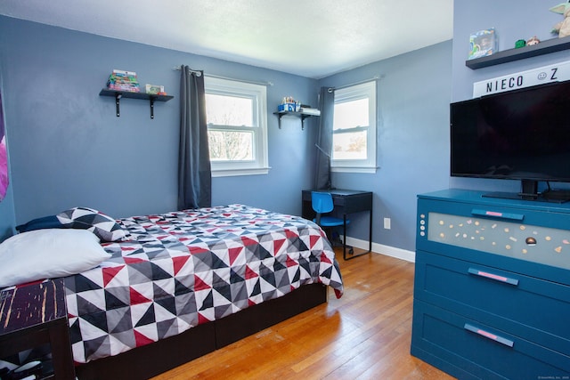 bedroom featuring baseboards and light wood finished floors