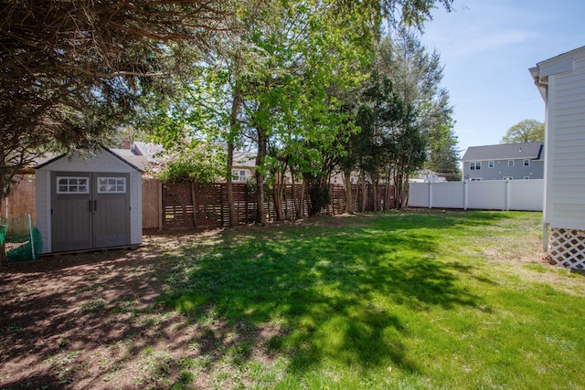 view of yard featuring a storage unit, a fenced backyard, and an outbuilding