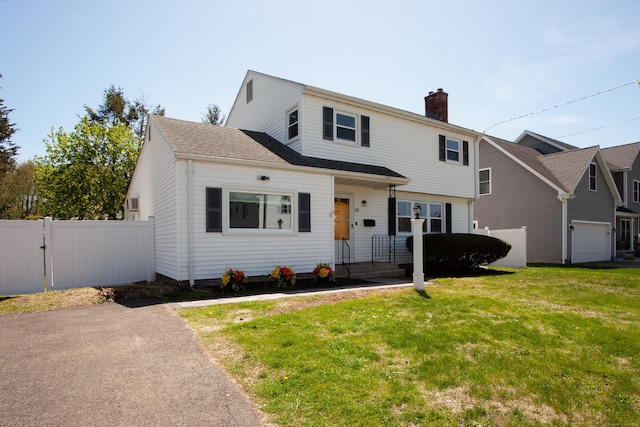 view of front of property featuring fence, a gate, a chimney, and a front yard