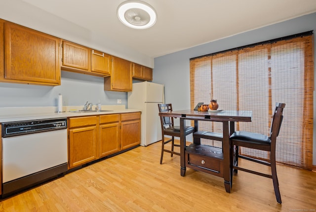 25 Deerwood Ln Unit 8, Waterbury, CT 06704 - kitchen featuring white appliances, a sink, light countertops, light wood-style floors, and brown cabinetry
