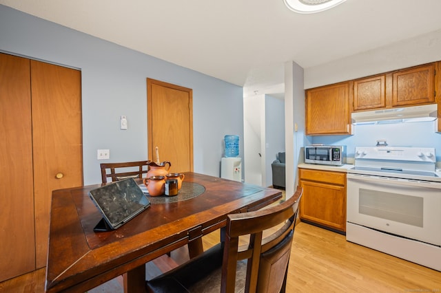 25 Deerwood Ln Unit 8, Waterbury, CT 06704 - kitchen featuring white electric range oven, under cabinet range hood, stainless steel microwave, and brown cabinets
