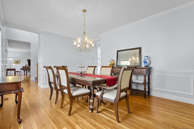 6 Old Farm Rd, Woodbridge, CT 06525 - dining area featuring an inviting chandelier, ornamental molding, a decorative wall, and light wood finished floors