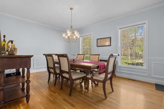 6 Old Farm Rd, Woodbridge, CT 06525 - dining area with an inviting chandelier, a decorative wall, light wood-style flooring, visible vents, and ornamental molding