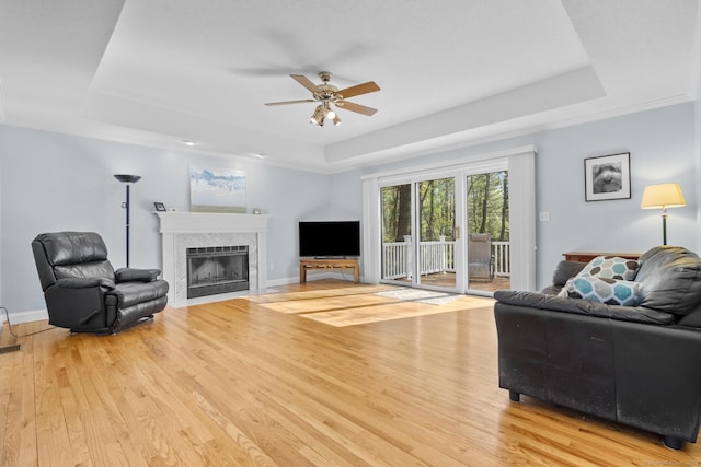 6 Old Farm Rd, Woodbridge, CT 06525 - living room with a ceiling fan, a tiled fireplace, a raised ceiling, and light wood-style floors