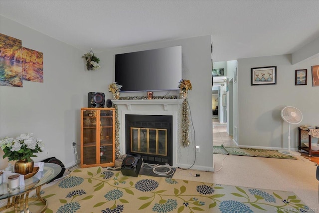 carpeted living area featuring a fireplace with flush hearth and baseboards