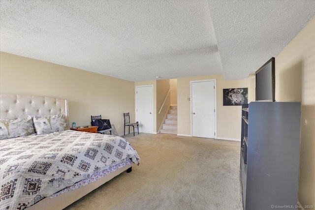 bedroom with baseboards, a textured ceiling, and light carpet