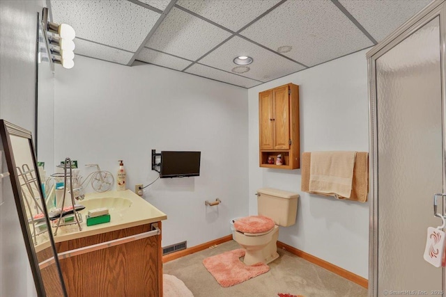 bathroom with vanity, toilet, baseboards, a drop ceiling, and visible vents