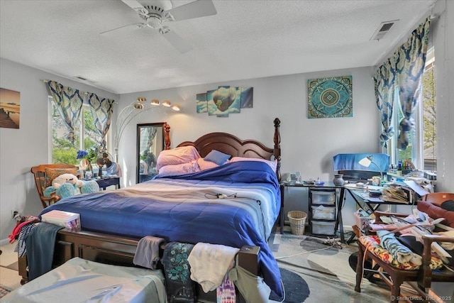 bedroom with visible vents, a textured ceiling, and multiple windows