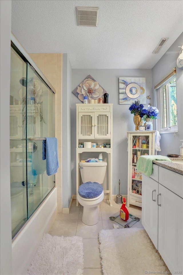 full bath with visible vents, a textured ceiling, tile patterned flooring, and toilet