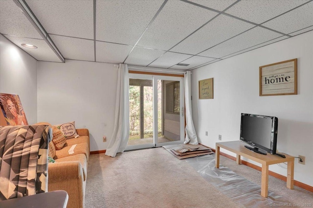 living room featuring baseboards, carpet floors, and a drop ceiling