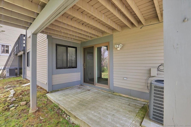 view of exterior entry with central air condition unit and a patio area