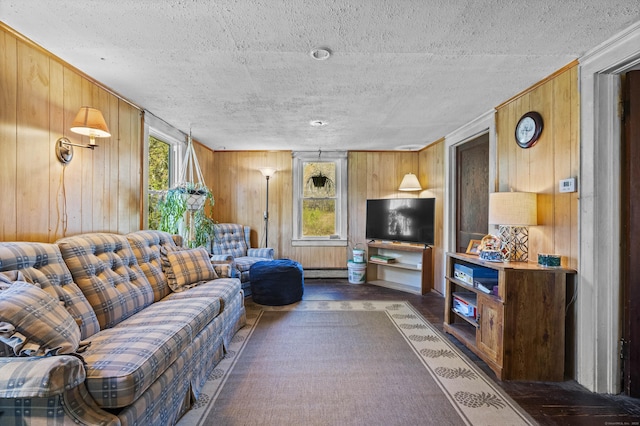 living area featuring wooden walls, a textured ceiling, a baseboard radiator, and wood finished floors