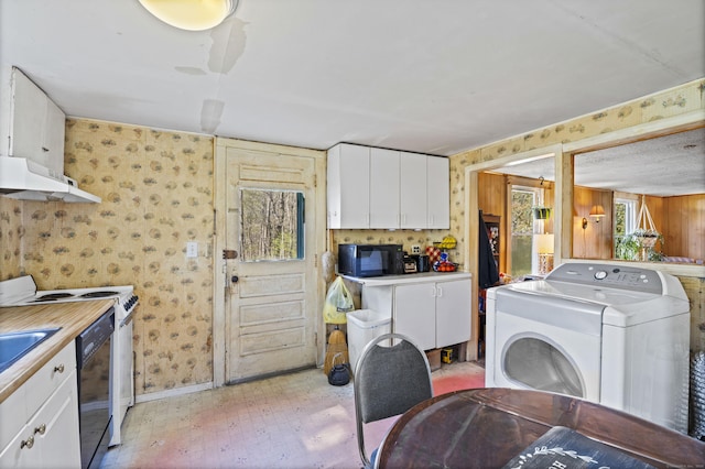 laundry area featuring laundry area, washer / clothes dryer, a sink, baseboards, and wallpapered walls