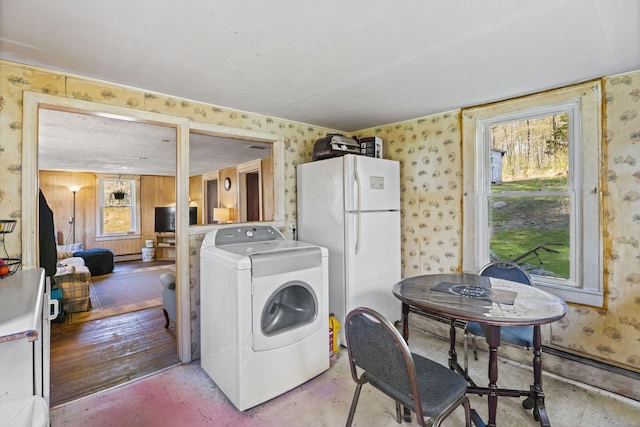 laundry room featuring washer / clothes dryer, wallpapered walls, baseboard heating, and laundry area