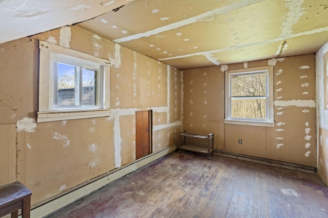 interior space with a healthy amount of sunlight, a baseboard heating unit, and hardwood / wood-style floors