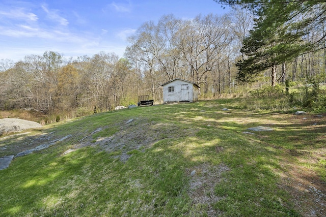 view of yard with an outdoor structure and a forest view