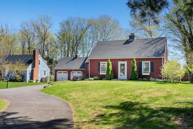 cape cod house featuring a garage, a front lawn, aphalt driveway, and a chimney