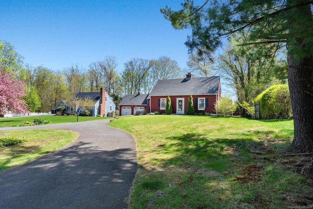 cape cod-style house with a garage, a chimney, driveway, and a front lawn