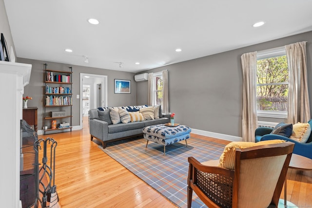 living room with recessed lighting, light wood finished floors, plenty of natural light, and a wall mounted AC