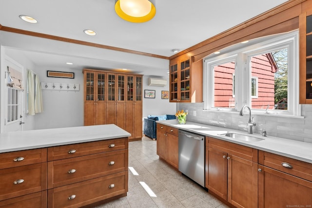 kitchen with crown molding, a sink, dishwasher, brown cabinetry, and a wall unit AC