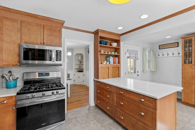 kitchen with crown molding, appliances with stainless steel finishes, brown cabinets, and light countertops