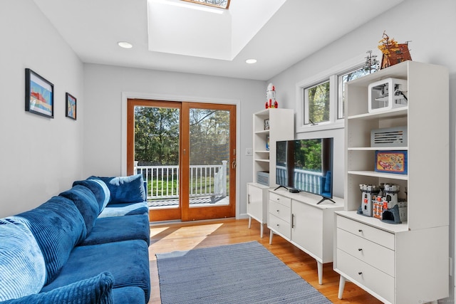 living area featuring recessed lighting, a skylight, and light wood finished floors