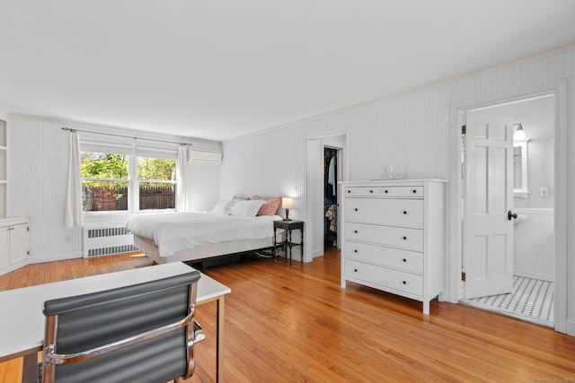 bedroom with crown molding, light wood finished floors, a wall mounted AC, and radiator heating unit