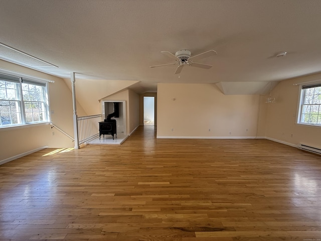 unfurnished living room with baseboards, ceiling fan, wood finished floors, and vaulted ceiling