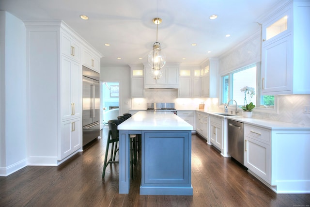 9 November Trl, Weston, CT 06883 - kitchen with appliances with stainless steel finishes, white cabinetry, backsplash, a breakfast bar, and a kitchen island