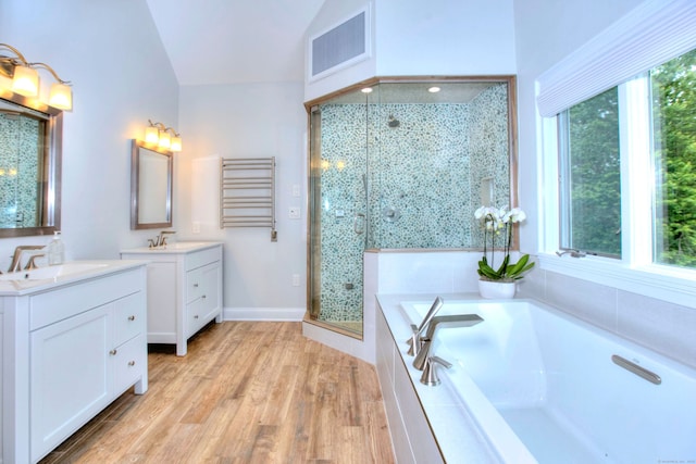 9 November Trl, Weston, CT 06883 - bathroom featuring a shower stall, two vanities, vaulted ceiling, a garden tub, and wood finished floors