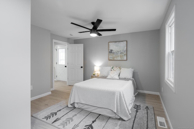 bedroom with visible vents, baseboards, ceiling fan, and wood finished floors