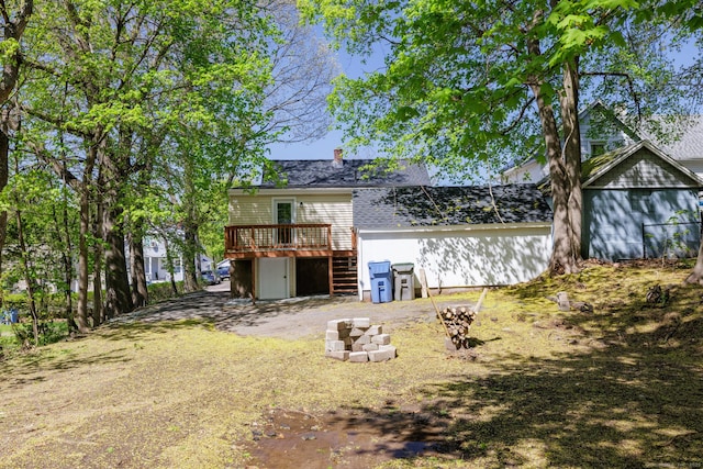 back of property with stairway, a wooden deck, and a chimney
