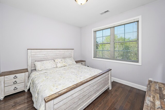bedroom with visible vents, baseboards, and dark wood-style floors