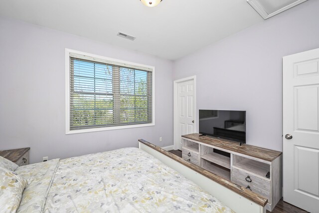 bedroom featuring visible vents, baseboards, and wood finished floors