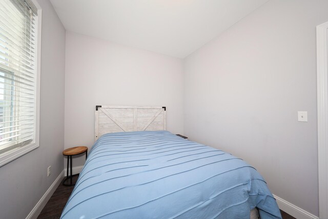 bedroom featuring baseboards and wood finished floors