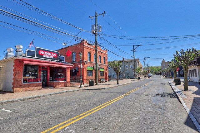 view of road featuring curbs, street lights, and sidewalks